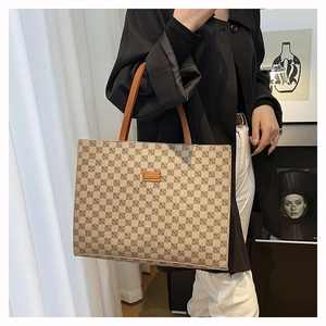 Detail of checkered tote bag with brown handles and Fashion logo for daily commuting