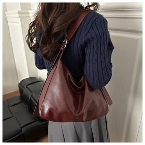 Détail d'un sac hobo bordeaux en similicuir brillant montrant la texture et la bandoulière