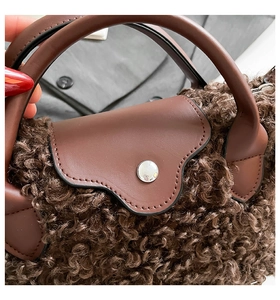 Detail of dark brown faux fur texture and smooth leather flap with silver metal buckle