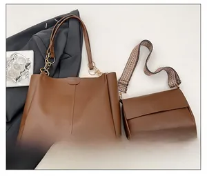Close-up of brown PU tote bag set with golden chain handle and herringbone strap