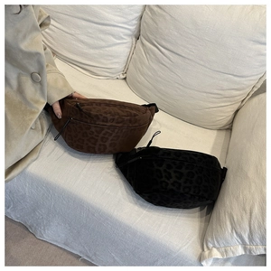 Detail of trendy leopard print crossbody waist bags in brown and black faux fur texture