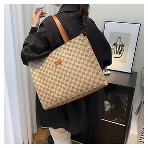 Close-up of a large vintage tote bag with chevron pattern worn on a shoulder