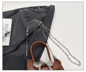 Détail du mini sac marron avec nœud en strass et bandoulière en chaîne argentée chic