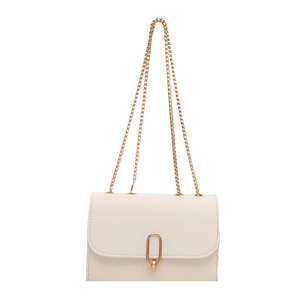 Minimalist beige crossbody bag with gold chain strap and oval metal buckle on white background
