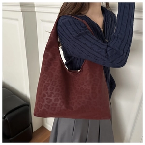 Deep burgundy leopard print tote bag styled with a knit sweater and grey pleated skirt