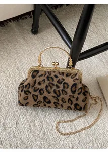 Detail of leopard print shell bag with gold ring handle and detachable chain strap