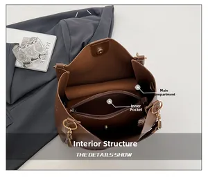 Detail of the large brown tote bag showing a main compartment and a zipper inner pocket