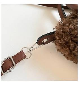 Detailed close-up of brown plush crossbody bag with silver buckle and leather strap