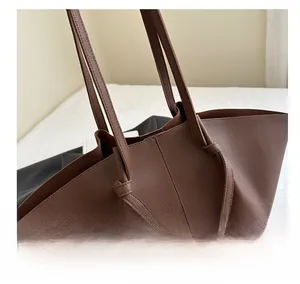 Close-up of brown pebbled faux leather tote bag showing intricate knot strap details