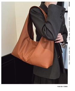 Detail of tan brown smooth PU leather Hobo shoulder bag worn with a grey blazer
