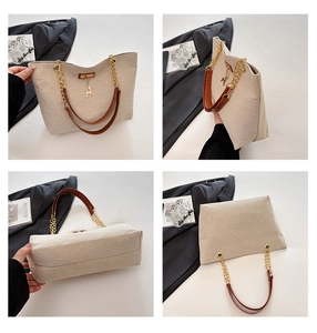 Detail view of beige canvas tote with brown leather straps and gold deer charm detail