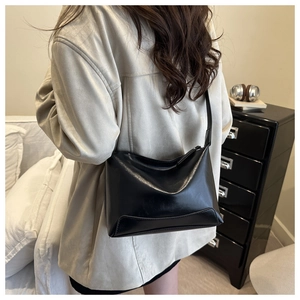 Minimalist black leather half-moon shoulder bag styled on model for daily commuting