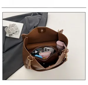 Brown tote bag interior showing large capacity with compartments for phone and umbrella