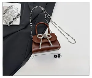 Vue détaillée du mini sac en cuir marron avec nœud en cristal et bandoulière chaîne