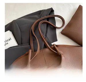 Detail of dark brown litchi pattern leather tote bag with matching inner zipper pouch