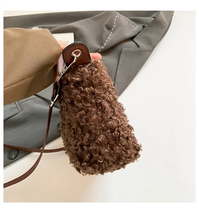 Detailed texture of brown faux shearling and dark brown leather strap on a crossbody bag