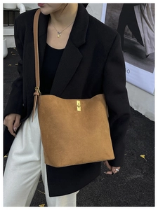 Vue de rue extérieure d'un sac seau en daim marron avec boucle de réglage en métal doré