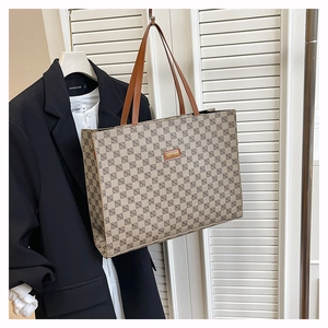 Close-up of vintage monogram tote bag featuring leather logo patch and luxury canvas