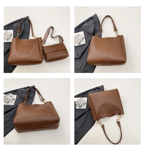 Detail of a 2-piece brown leather tote set with embroidered strap and gold chain accent