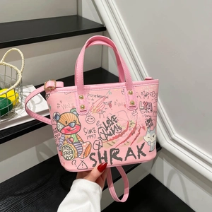 Sac cabas rose à imprimé graffiti avec ours et détails dorés sur un support minimal