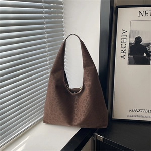 Retro leopard print tote bag with wide shoulder strap in a minimalist sunlit room