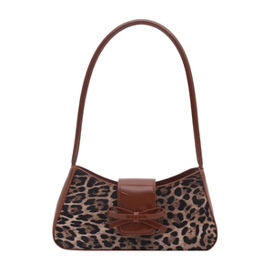 Retro leopard print underarm bag with brown lacquer trim and bow detail on white backdrop
