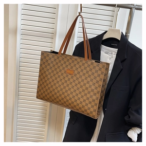 Detail of vintage monogram tote bag with brown leather handles and fashion logo patch