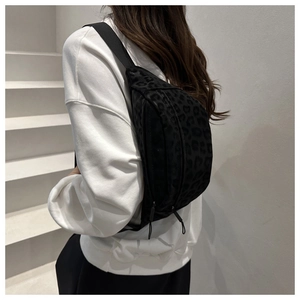 Detail of black leopard print crossbody bag with adjustable strap and flocking texture