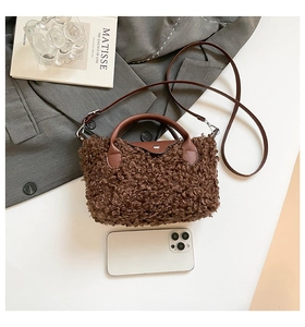 Close-up of brown plush faux fur bag with leather straps on a grey blazer context