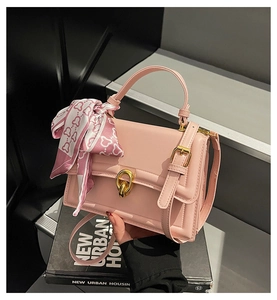 Close-up of pink PU leather handbag with gold twist lock and elegant floral scarf detail