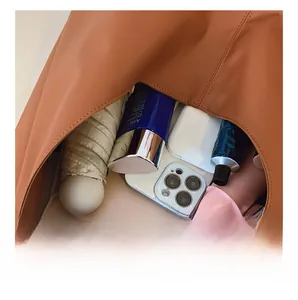 Interior view showing the large capacity of the caramel tote bag with daily essentials