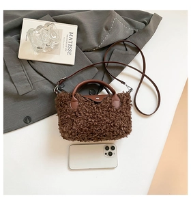 Close-up of brown faux fur handbag with leather handle and silver metal hardware