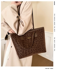 Detail of leopard print tote bag featuring brown straps and fashion bag typography