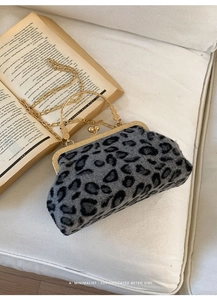Retro leopard print plush handbag with golden chain strap on a minimalist white sofa