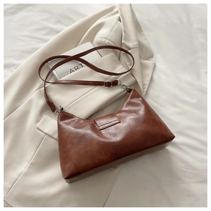 Detail of vintage brown PU leather shoulder bag with silver buckle and stud hardware
