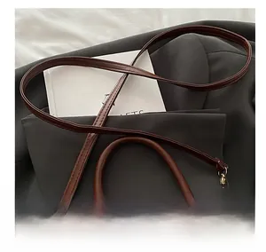 Close-up of adjustable leather shoulder strap and gold hardware on retro handbag
