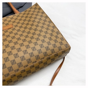 Detailed close-up of brown vintage monogram tote bag with embossed leather label