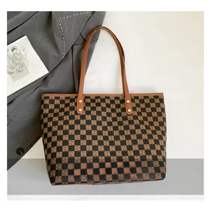 Dettaglio della grande borsa tote a scacchi marrone con manici in pelle sintetica e stile retro