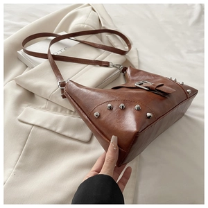Detailed view of brown vintage PU leather underarm bag with silver studs and belt buckle