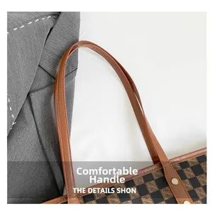 Dettaglio della borsa tote a scacchi con manici rinforzati e rivetti dorati lucidi
