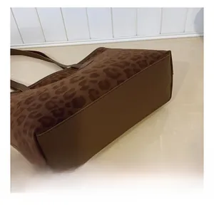 Close-up of leopard print tote bag with reinforced brown leather base and double stitching