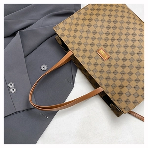 Detail of vintage brown tote bag with pattern on grey blazer for a business look