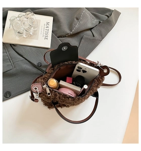Interior view showing the capacity of a brown teddy plush bucket bag with daily items