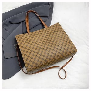 Flat lay of brown monogram tote bag with adjustable straps and luxury texture