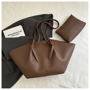 Detail of dark brown lychee textured tote bag with matching zippered pouch on white fabric