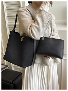 Gros plan d'un ensemble cabas noir avec fermoir doré et pochette assortie élégante