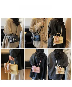 Detailed views of multi-color small square bags with silk scarves and heart buckles