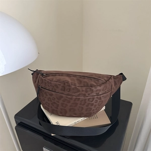 Brown leopard print chest bag with black nylon strap on a magazine in a cozy setting