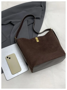 Détail du sac cabas vintage en daim marron avec boucle dorée et patchwork en cuir élégant