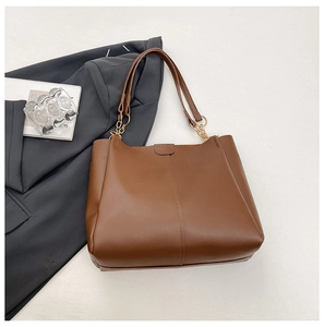 Brown leather tote bag with metal chain strap detail and minimalist vertical seam